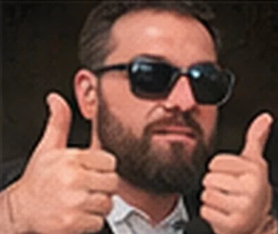 Apoiador de óculos escuros faz sinal de positivo com as duas mãos.